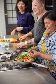 a group of women preparing food in a kitchen