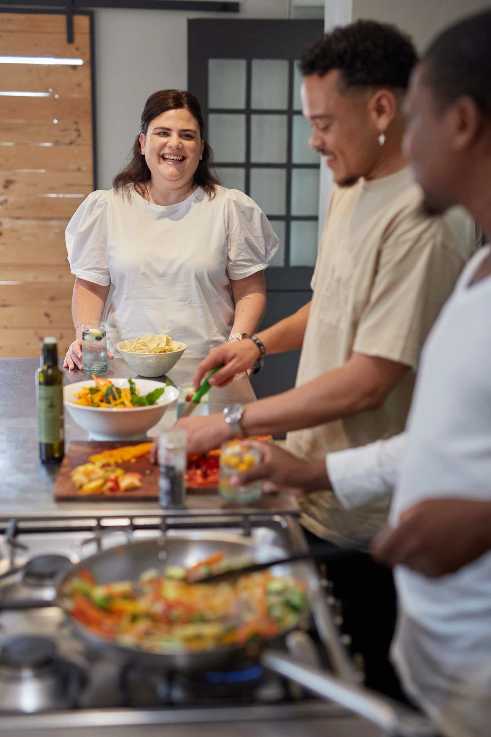 Friends preparing a colourful healthy meal together in a kitchen
