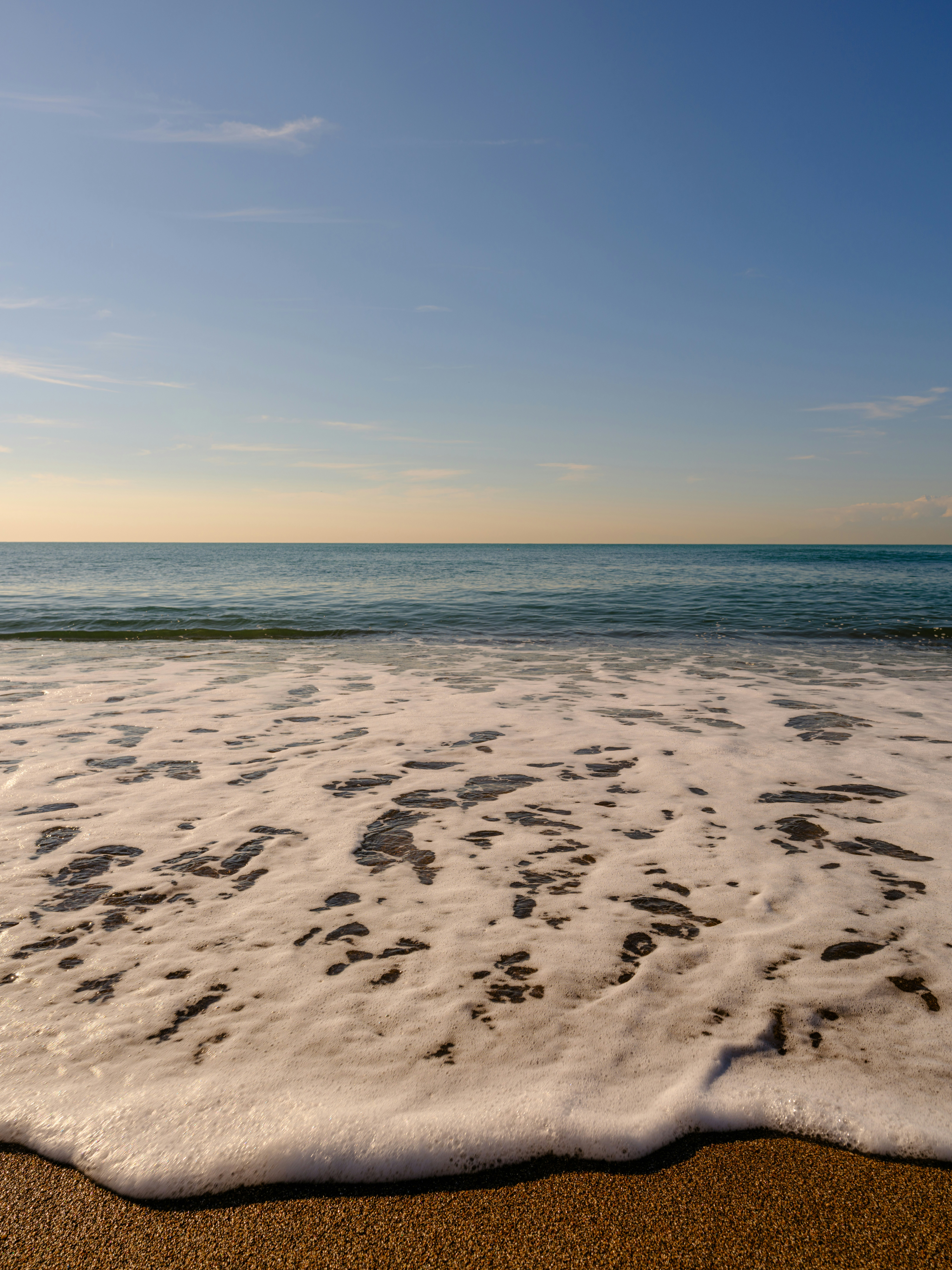 Uma praia de areia com ondas que chegam à costa foto – Imagem grátis sobre  Praia na Unsplash, image size:3000x4000