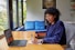a woman sitting at a table with a laptop