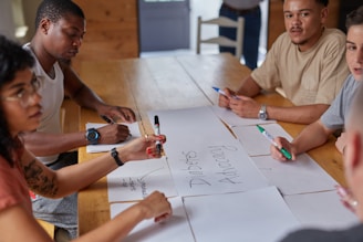 A brand sitting around a wooden table discussing brand awareness ideas