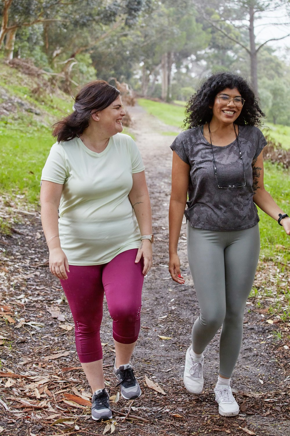 a couple of women walking down a dirt road