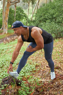 Outdoor scene capturing a man stretching before a workout, dressed in breathable strideforge activewear.