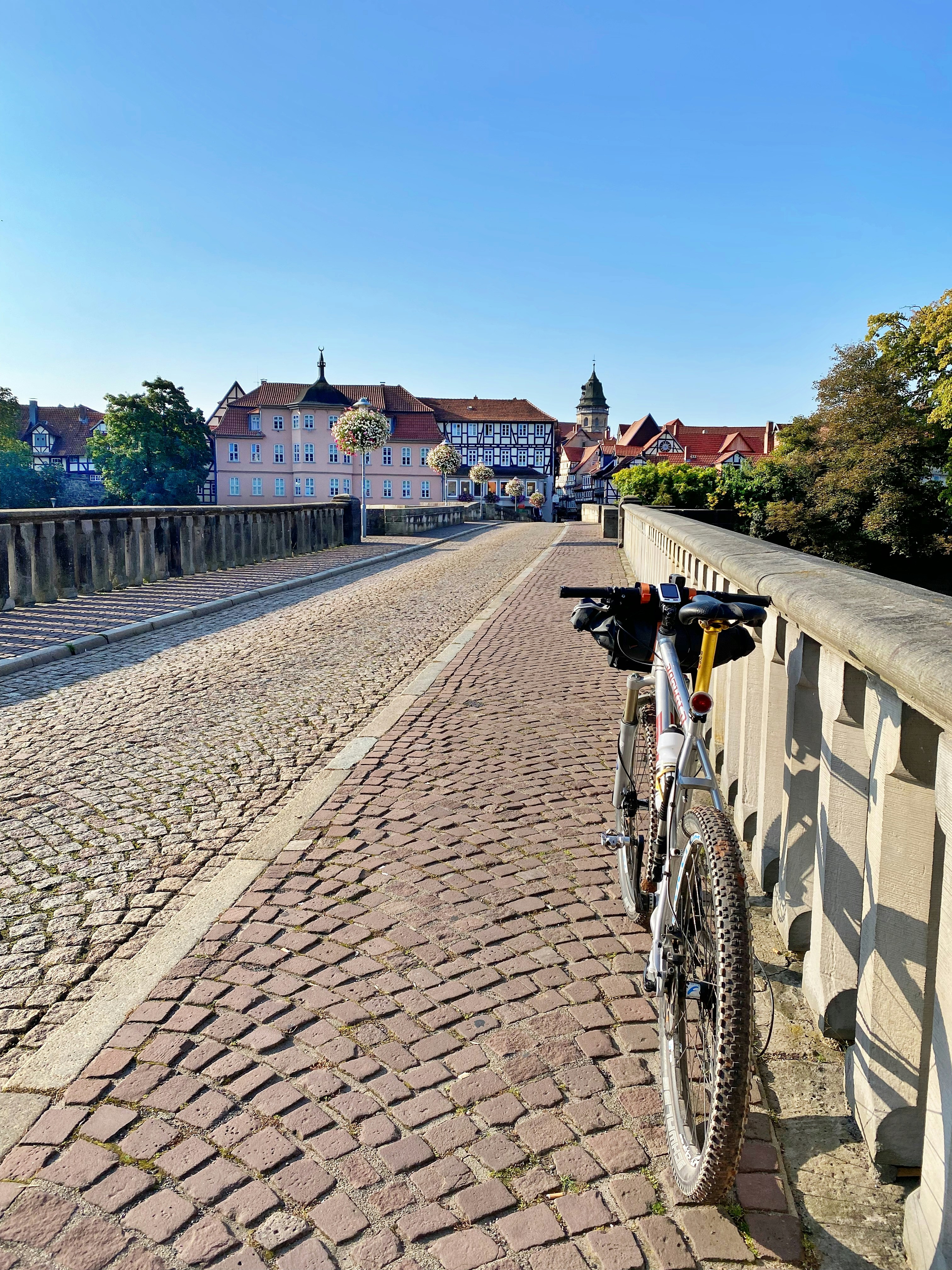 a bicycle parked on the side of a brick road