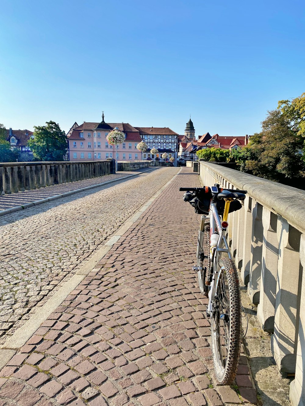 a bicycle parked on the side of a brick road