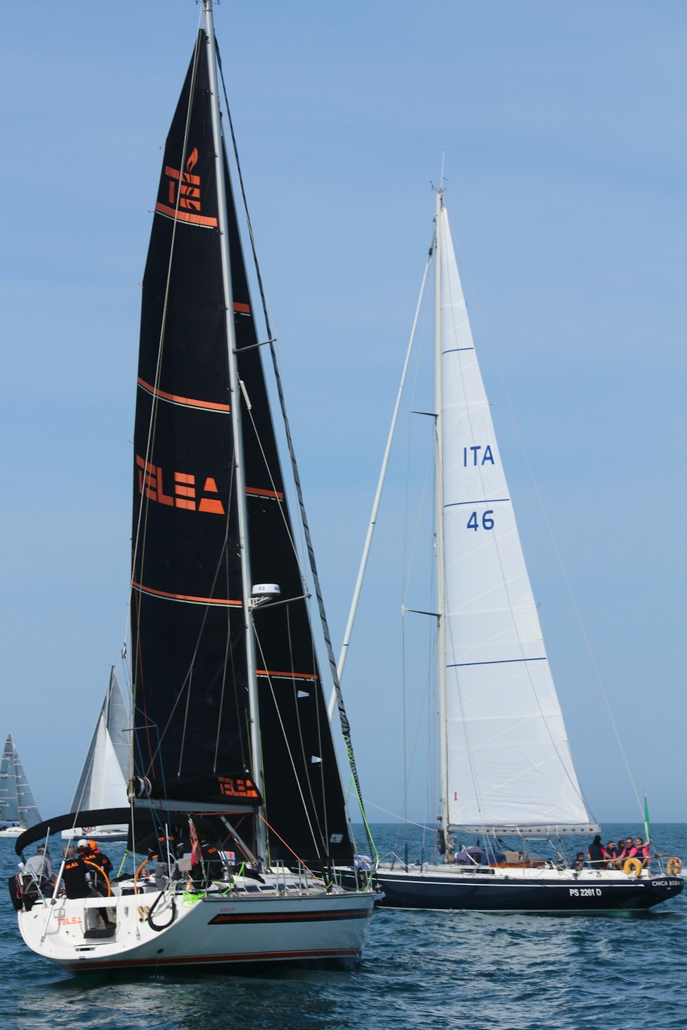 two sailboats in the water near each other