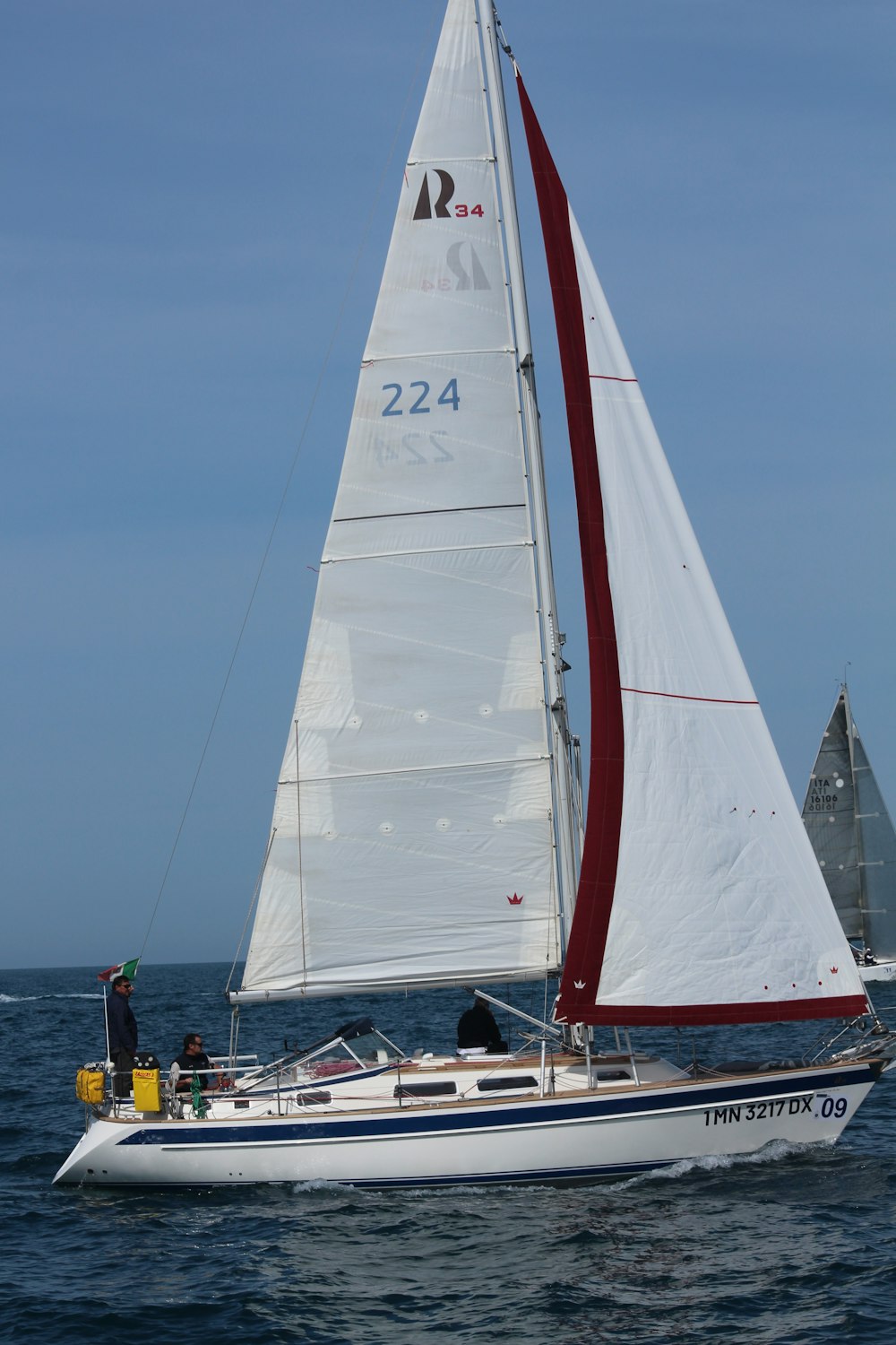 a sailboat with a red sail is in the water