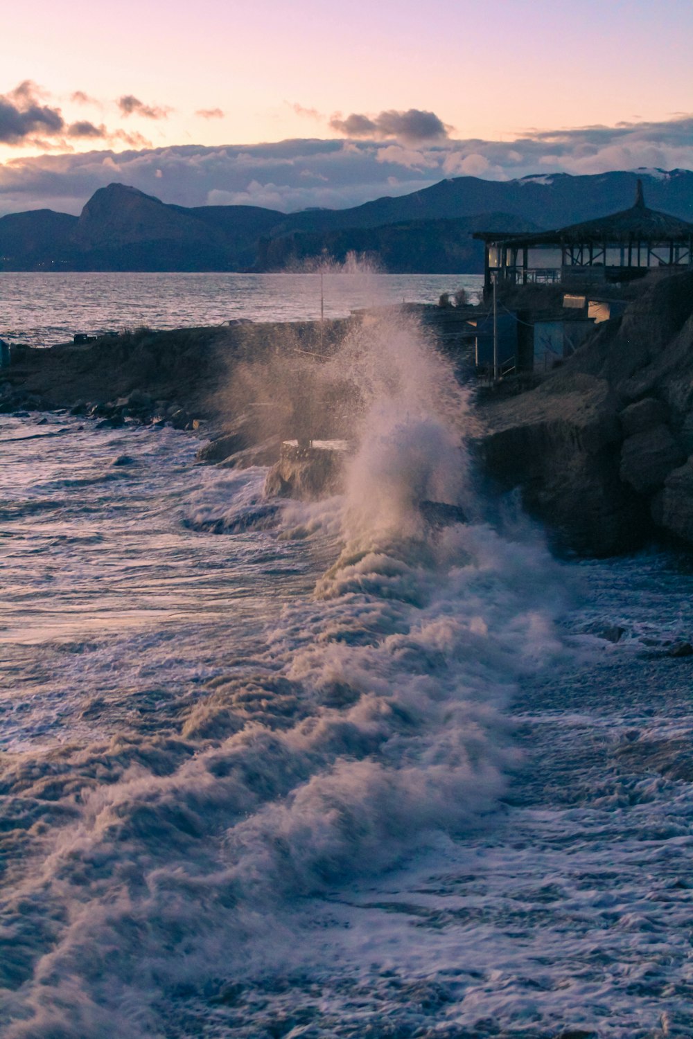 a large wave crashing into the shore of a body of water