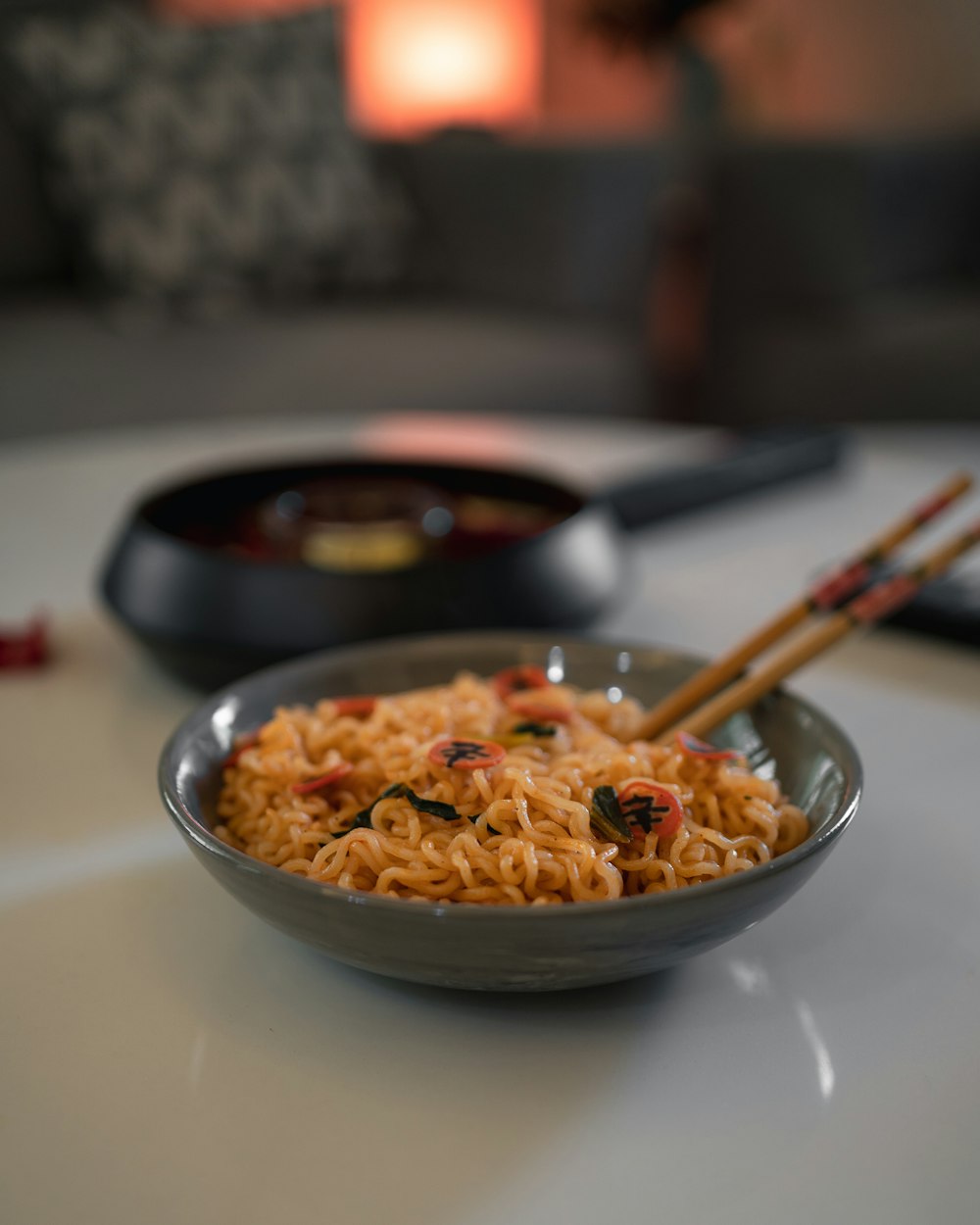 una ciotola di noodles con bacchette su un tavolo