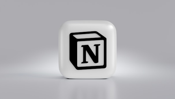 A cube-shaped object with a prominent black N logo in the center, set against a light gray background. The cube is three-dimensional with a smooth, white surface.