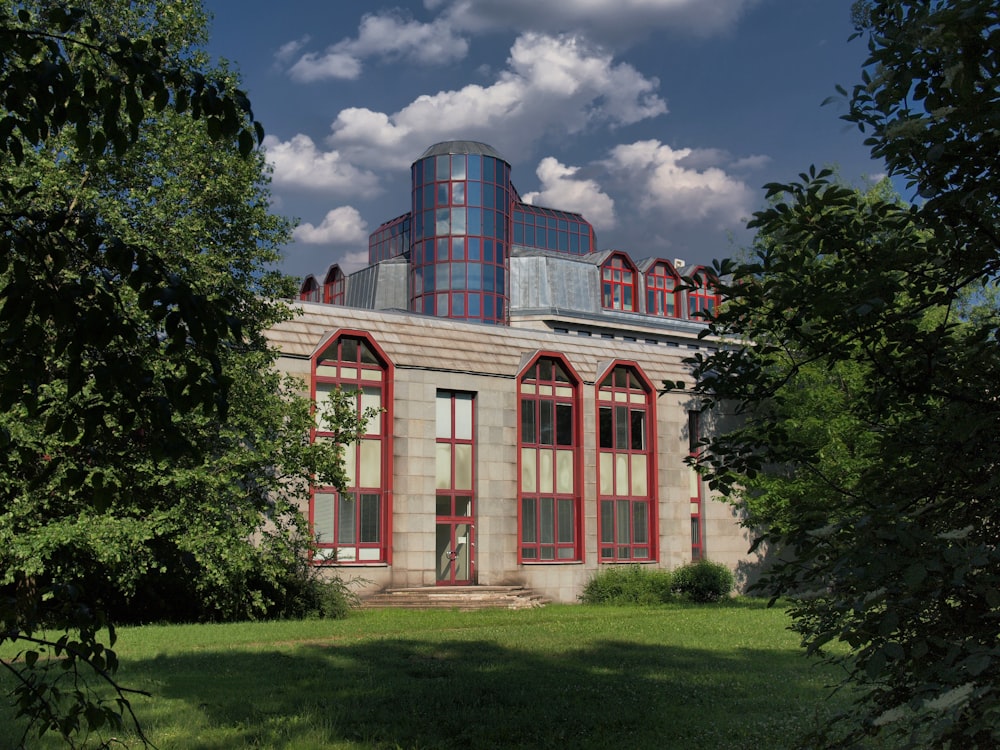 a large building with red windows and a sky background