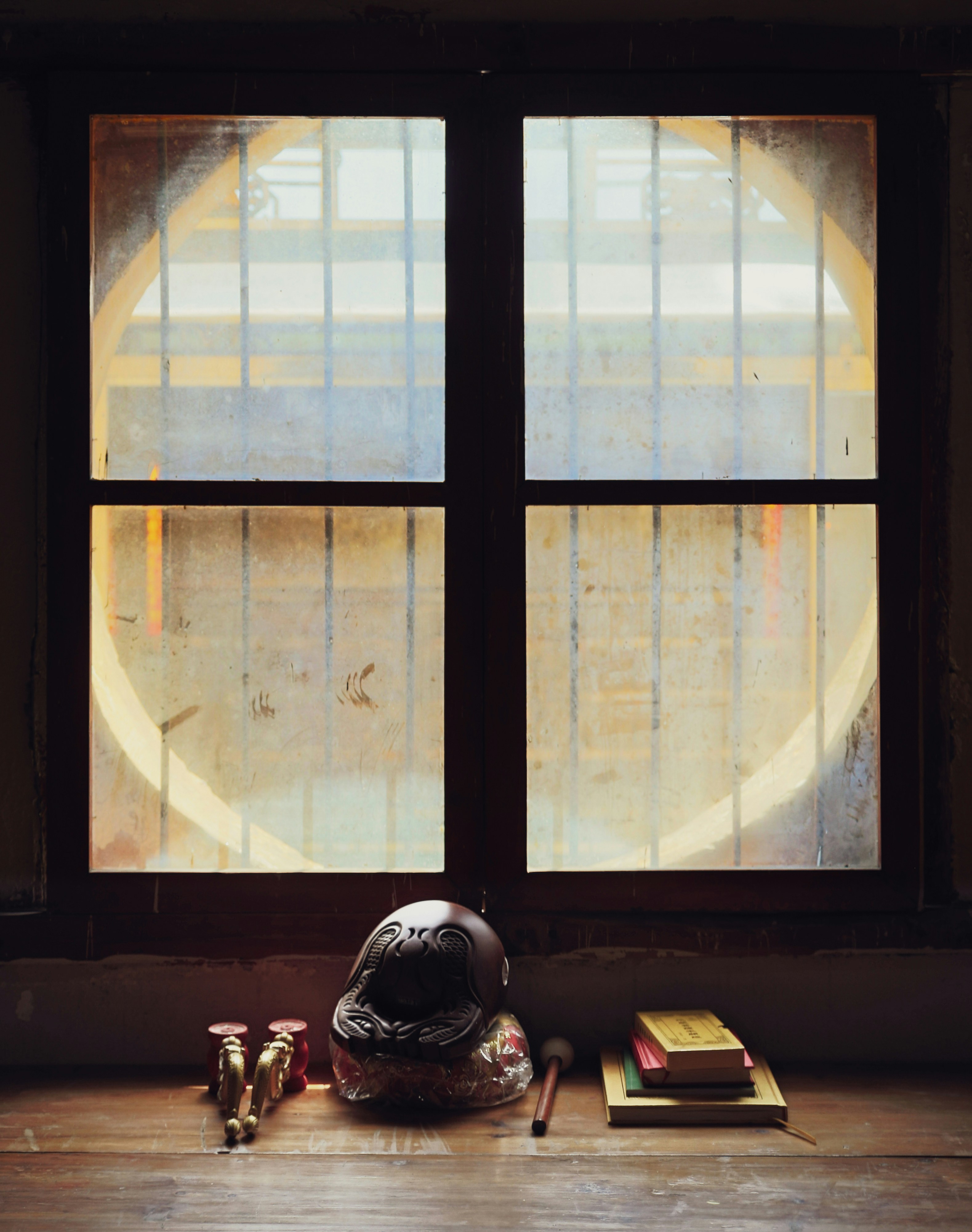 a helmet sitting on top of a wooden table next to a window