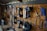 A well-organized workshop scene displays various power tools and hand tools neatly hung on a wooden wall. The tools include drills, screwdrivers, pliers, and wrenches, among others. The background is made of wooden planks, creating a rustic ambiance.