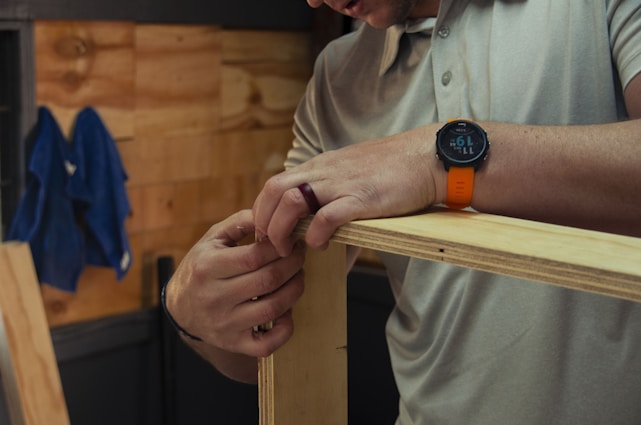 A friendly handyman assembling a piece of furniture in a bright, cozy living room.
