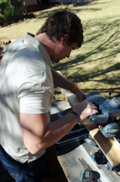 a man sanding a piece of wood with a circular saw