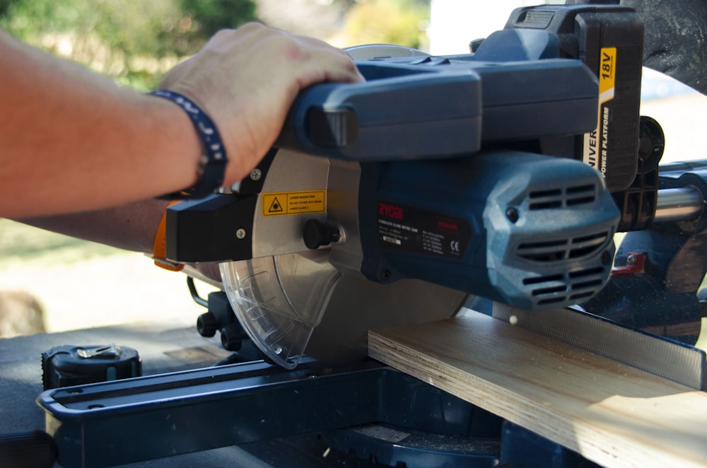 a person using a circular saw to cut a piece of wood