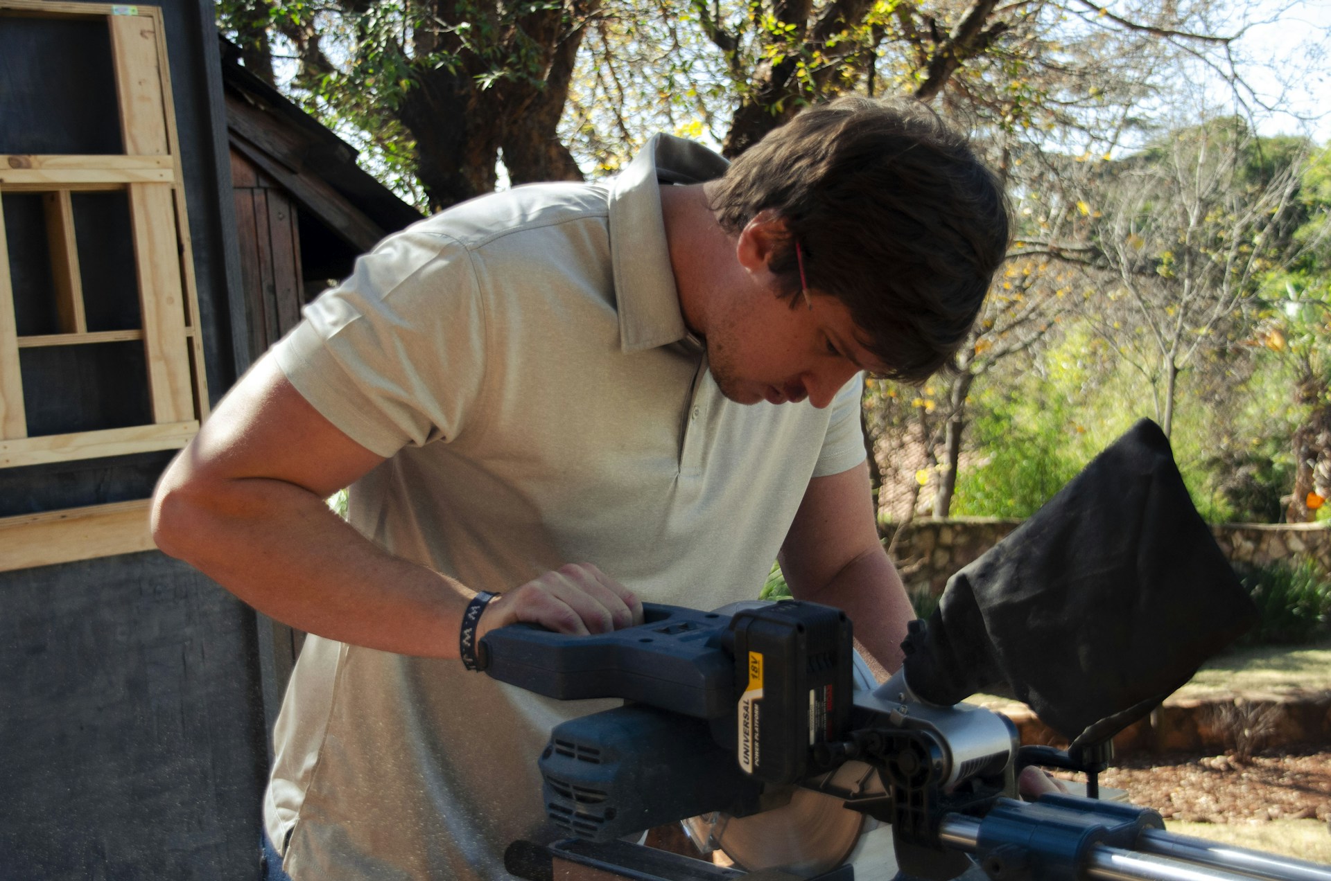 a man using a circular saw to cut a piece of wood