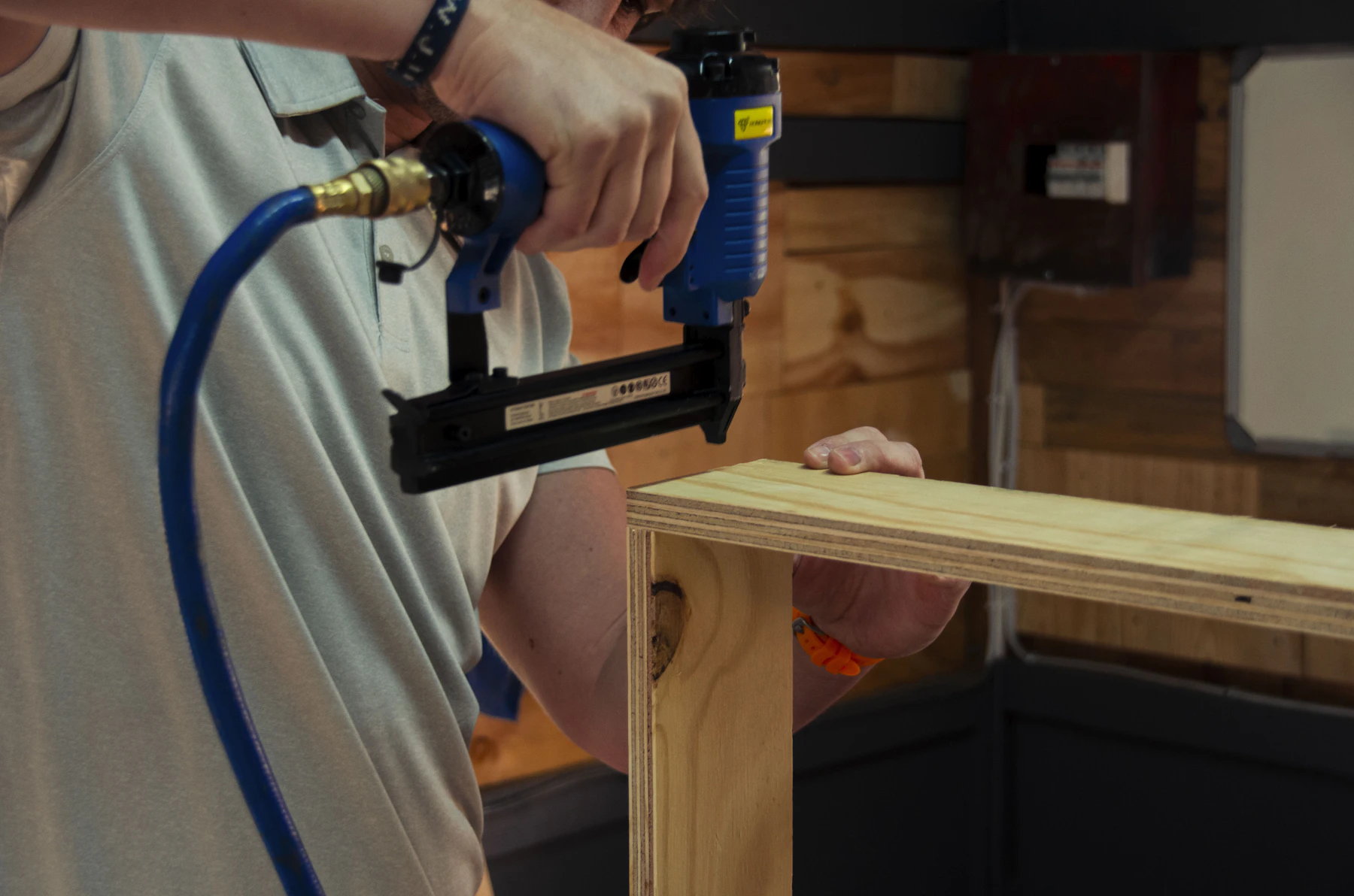 Craftsman using a power drill on wood in a workshop