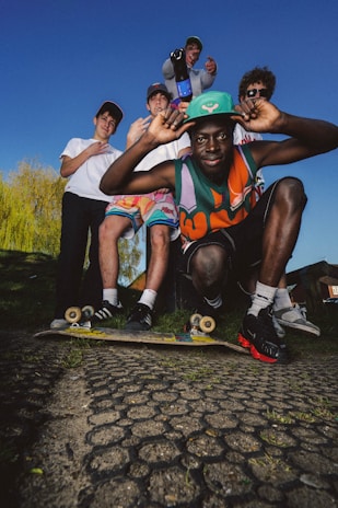 a group of young men sitting on top of a skateboard