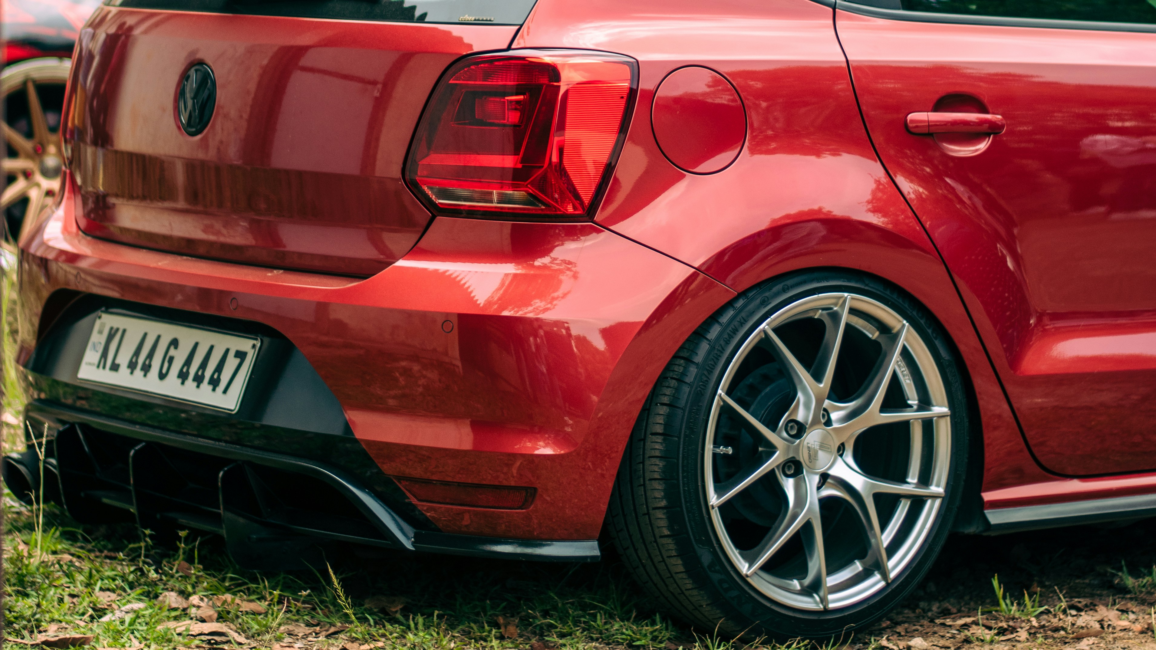 a close up of a red car parked in a field