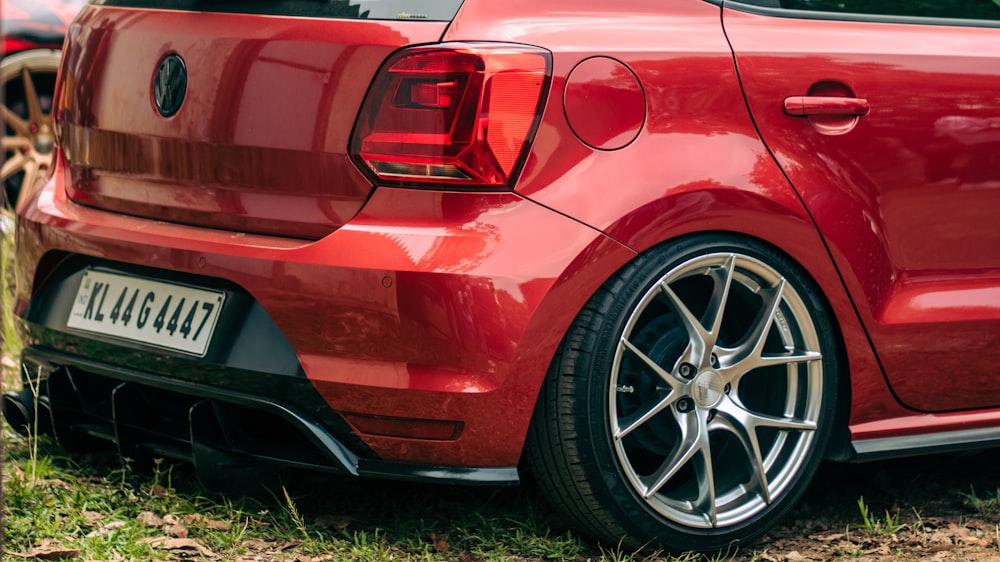 a close up of a red car parked in a field