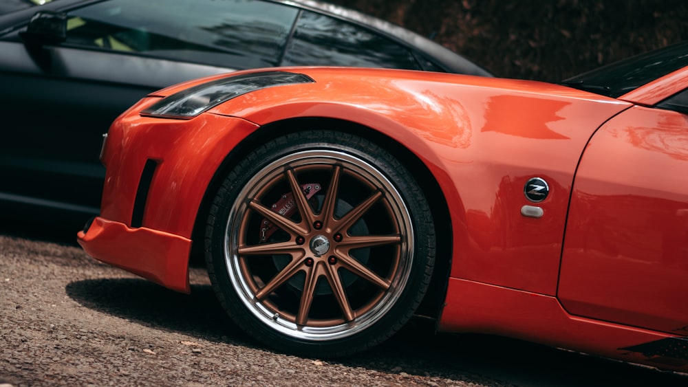 a red sports car parked next to a black car