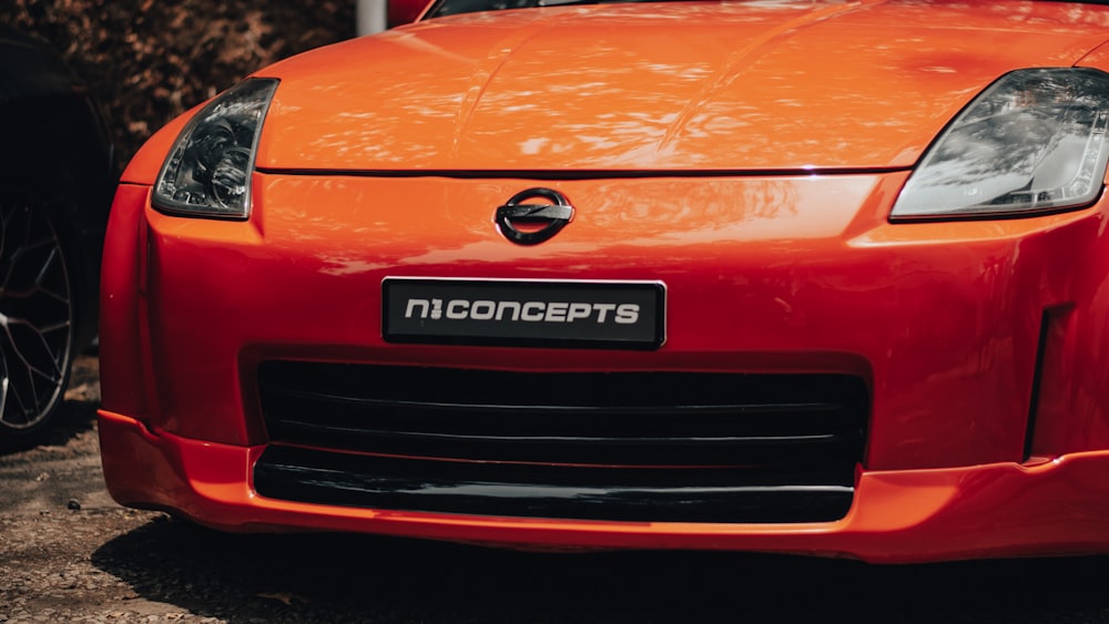 a close up of the front of an orange sports car