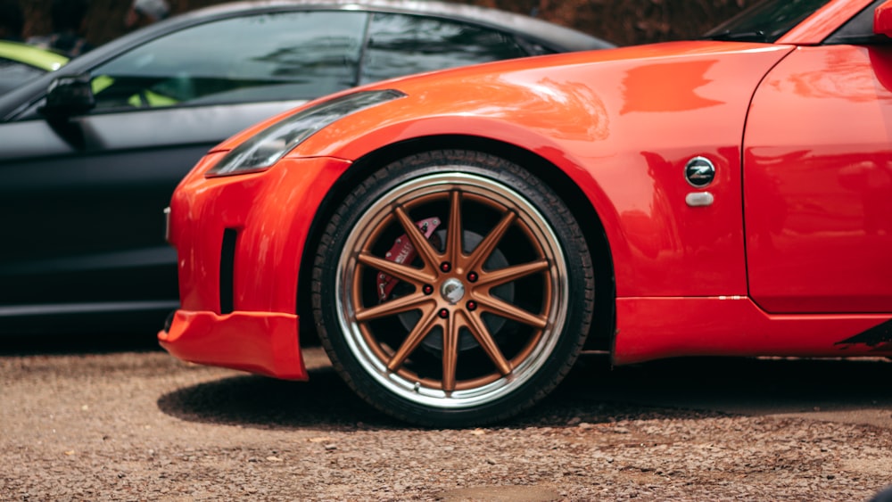 a red sports car parked next to a black car