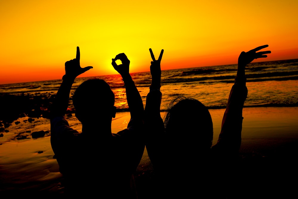 a couple of people that are standing in the sand