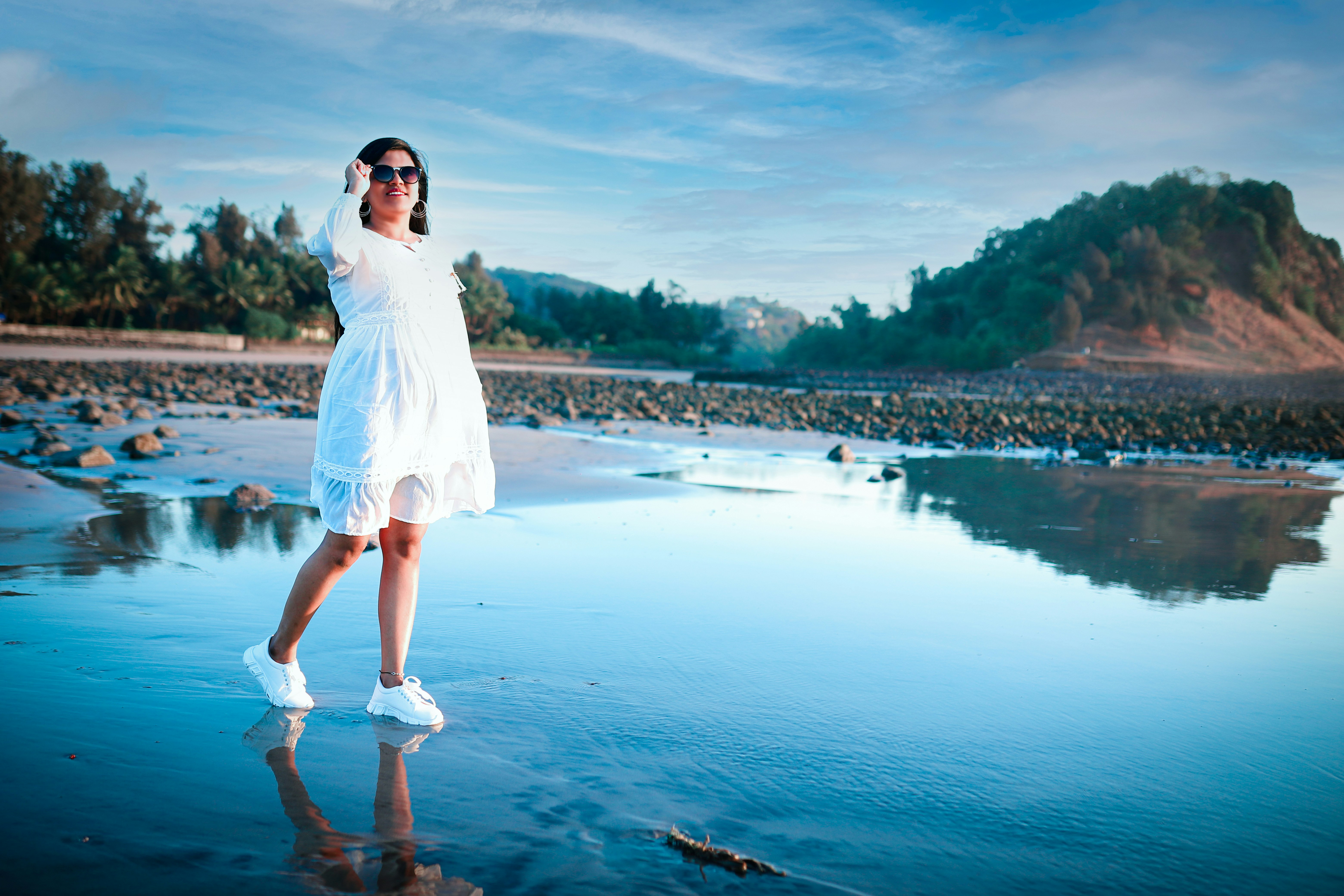 A woman in a white dress standing on a beach photo – Free Prewedding ...