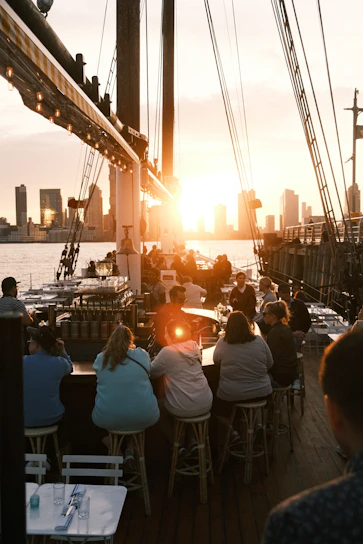A lively group enjoying a sunset boat party on the NYC skyline with laughter and music in the air.