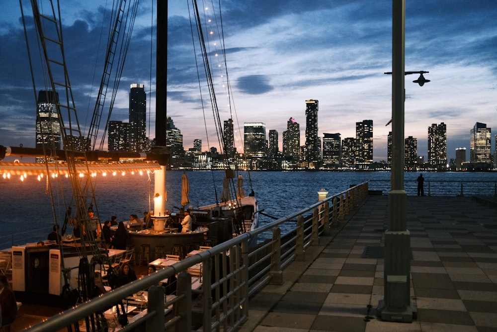 a boat docked at a pier with a city in the background