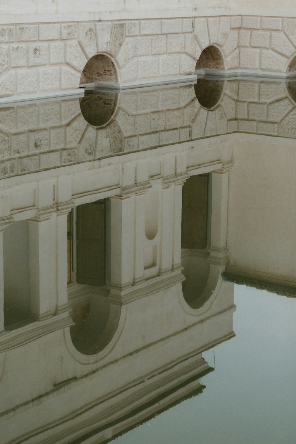 a reflection of a building in a pool of water