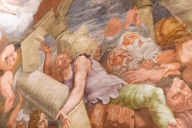 A classical fresco depicting a dramatic scene with multiple figures intertwined amidst falling columns. The expressions on the figures' faces convey distress and urgency. The style is reminiscent of Renaissance art, with an emphasis on movement and emotion.