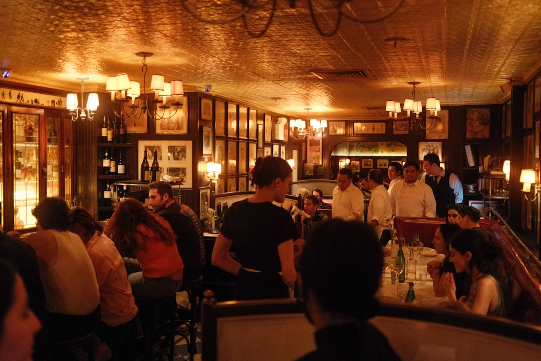 a group of people sitting at tables in a restaurant,
