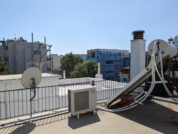 Maintenance technician checking and cleaning CCTV equipment on a rooftop