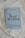 A book titled 'Royal Wedding' by Marina Minelli rests on an ornate white lace fabric. The book has a light blue cover with elegant floral patterns and bold black text. At the bottom, there is a subtitle in Italian.