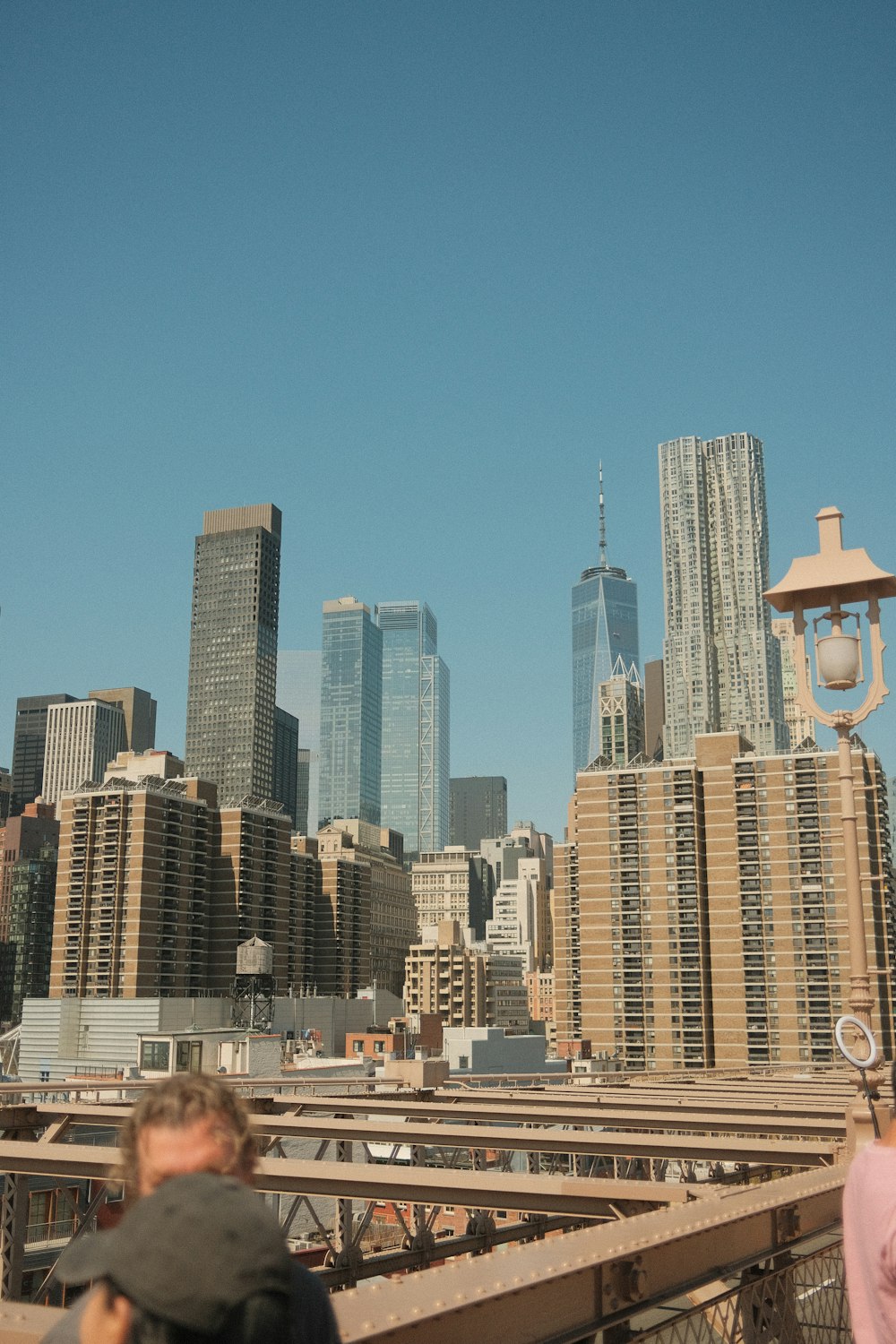 a man walking across a bridge next to tall buildings