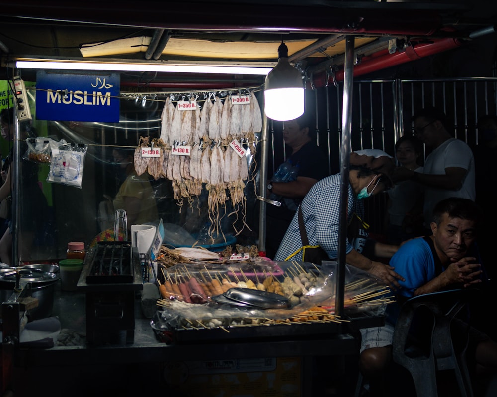 a group of people standing around a food stand