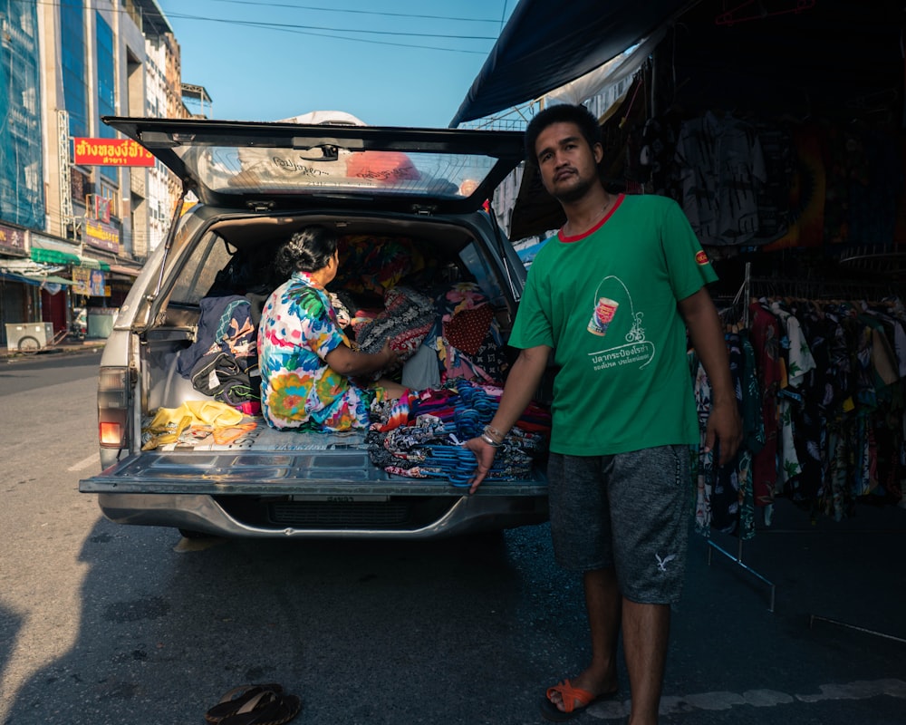 a man standing next to a truck filled with items