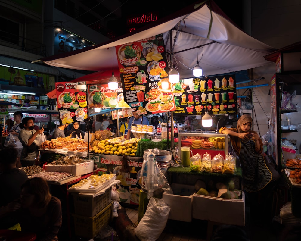 a woman standing in front of a fruit stand