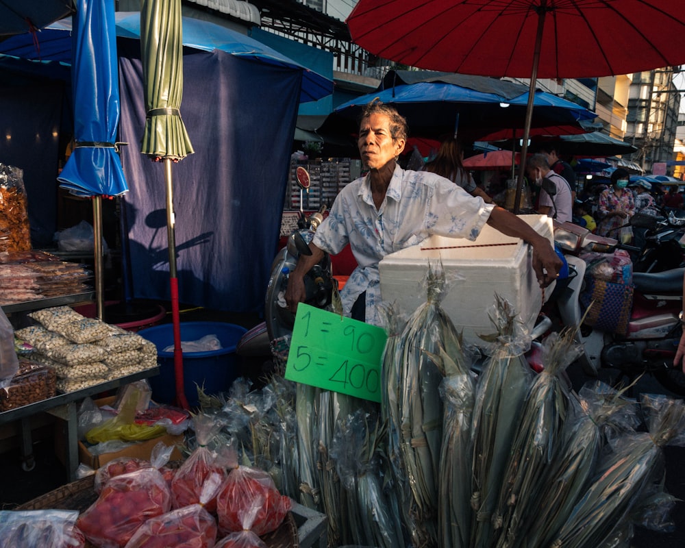 a man standing in front of a pile of fish