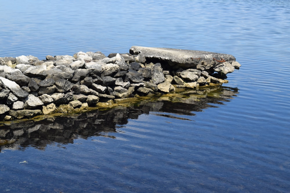 a rock wall sitting in the middle of a body of water