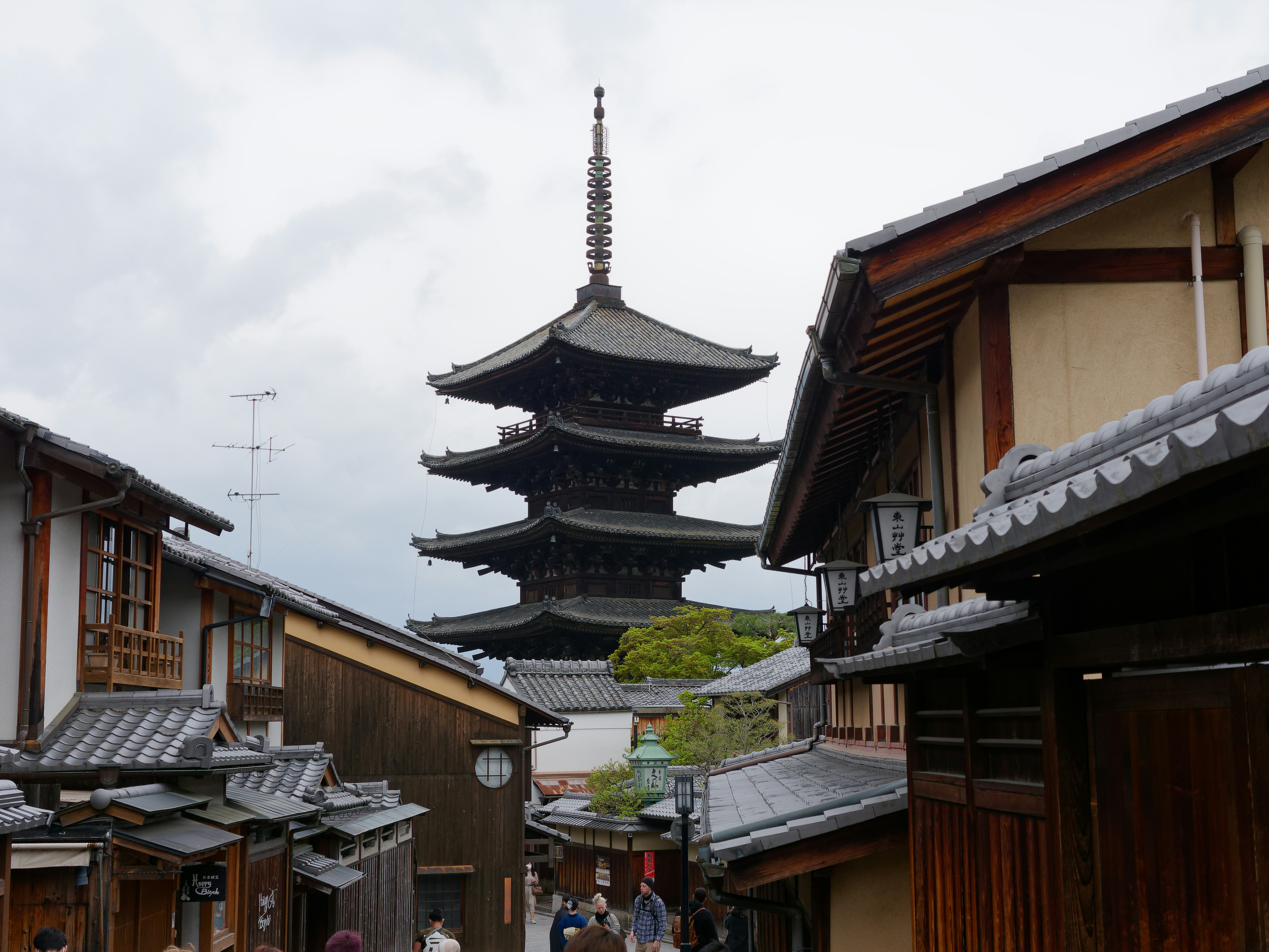 Un groupe de personnes marchant dans une rue à côté de grands immeubles