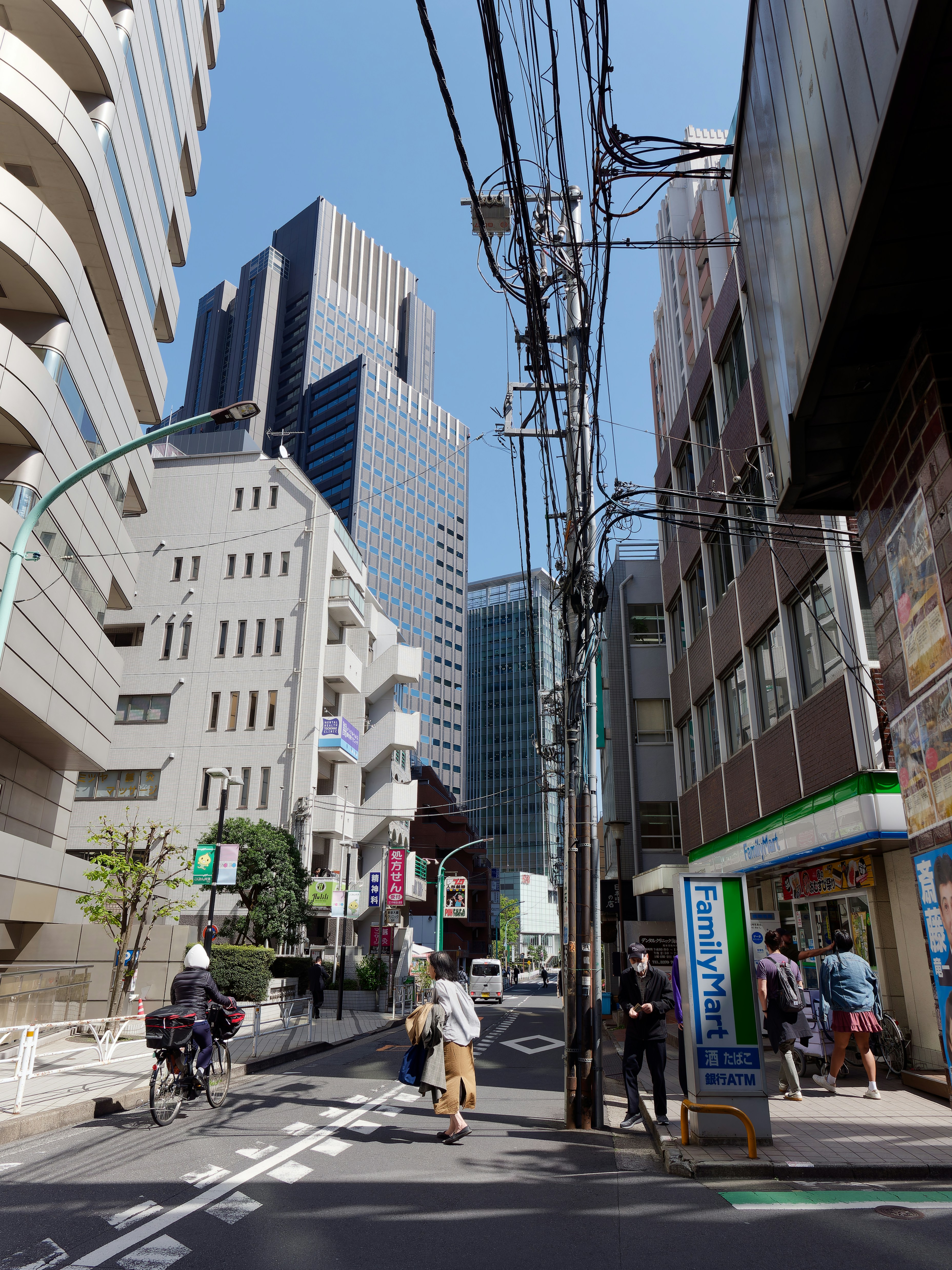 a group of people walking down a street next to tall buildings