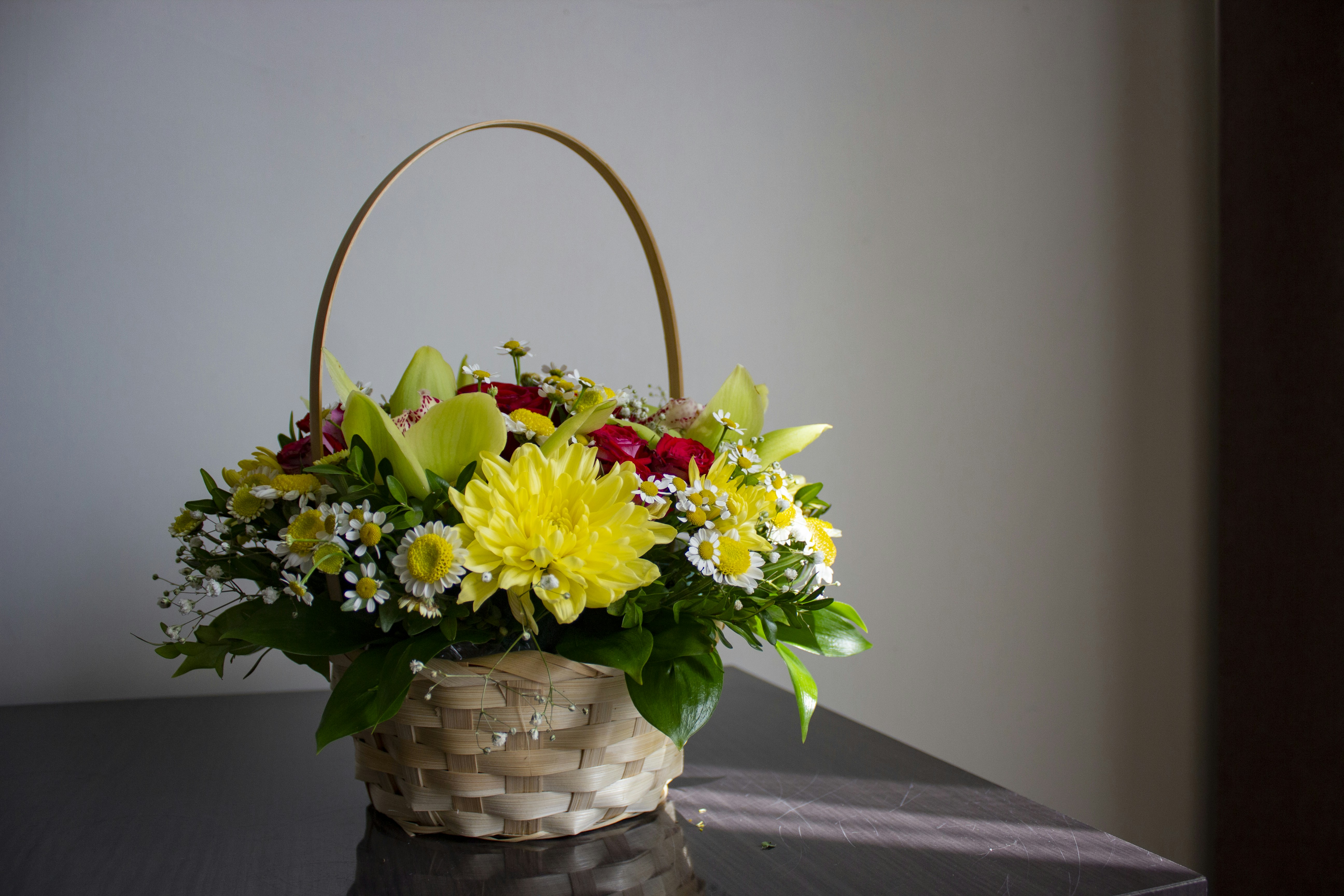 Una canasta llena de flores sentada encima de una mesa