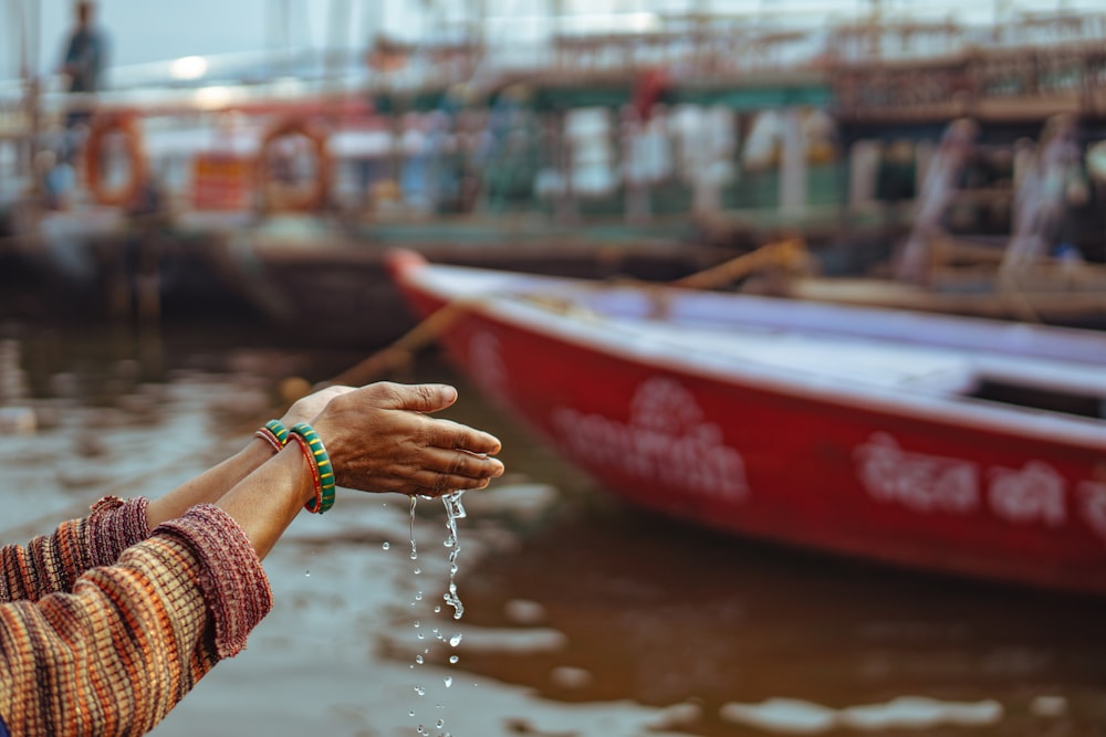 a woman is holding out her hand to a boat