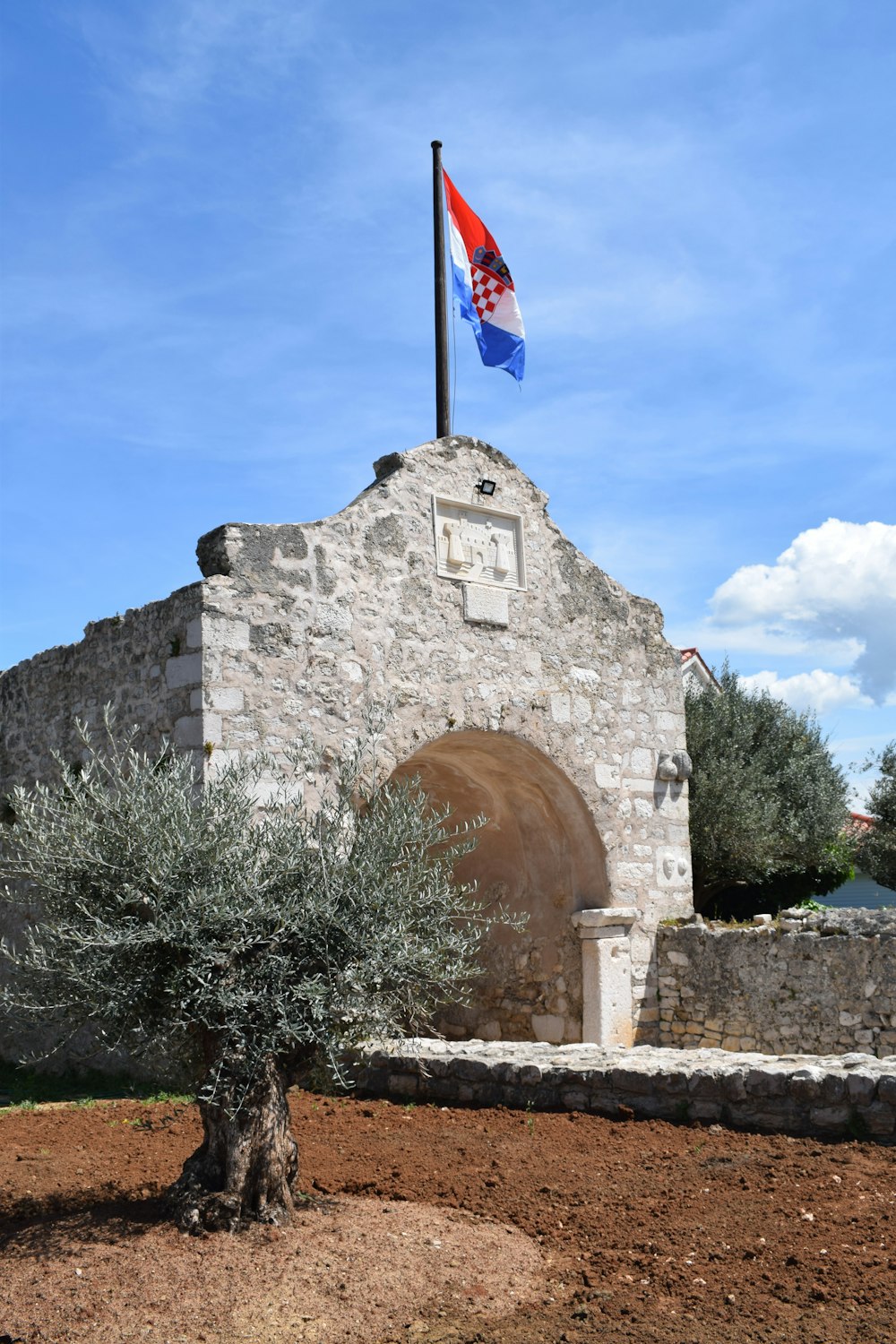 an old stone building with a flag on top of it