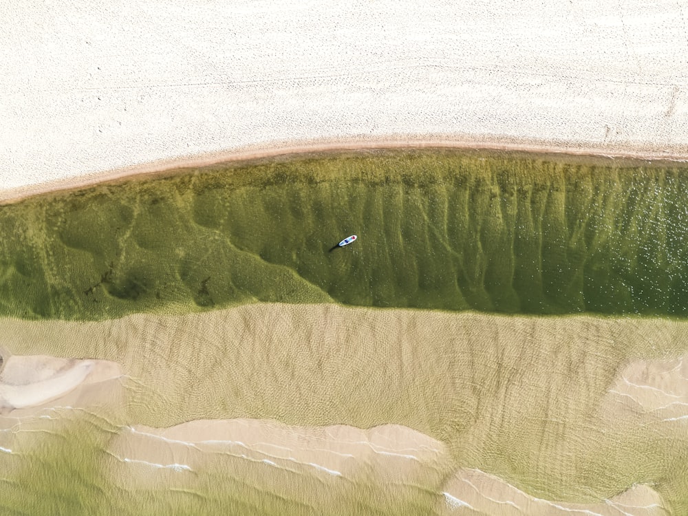 an aerial view of a small boat in a body of water