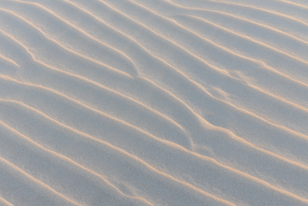 a sand dune with wavy lines in the sand